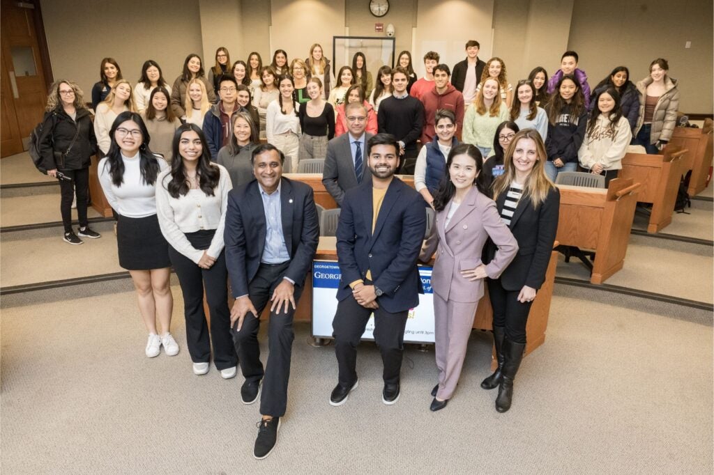 Georgetown McDonough students pose with Professor Kelly Lee in Hariri Building caseroom