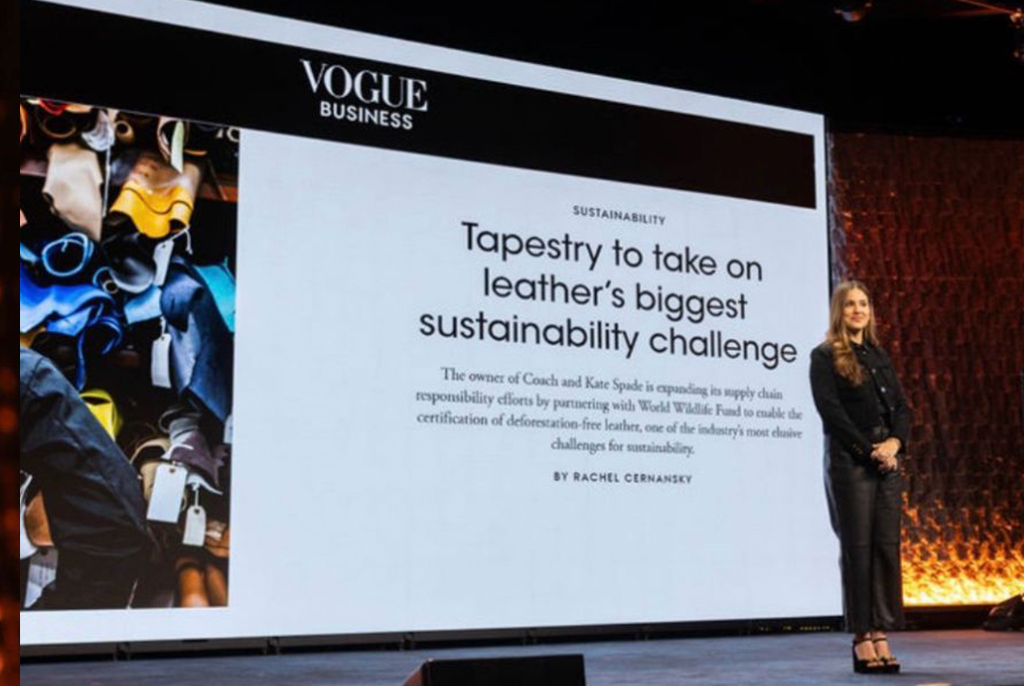 Julia Furnari speaking on stage at the NRF Foundation Student Program in New York with a large slide behind her